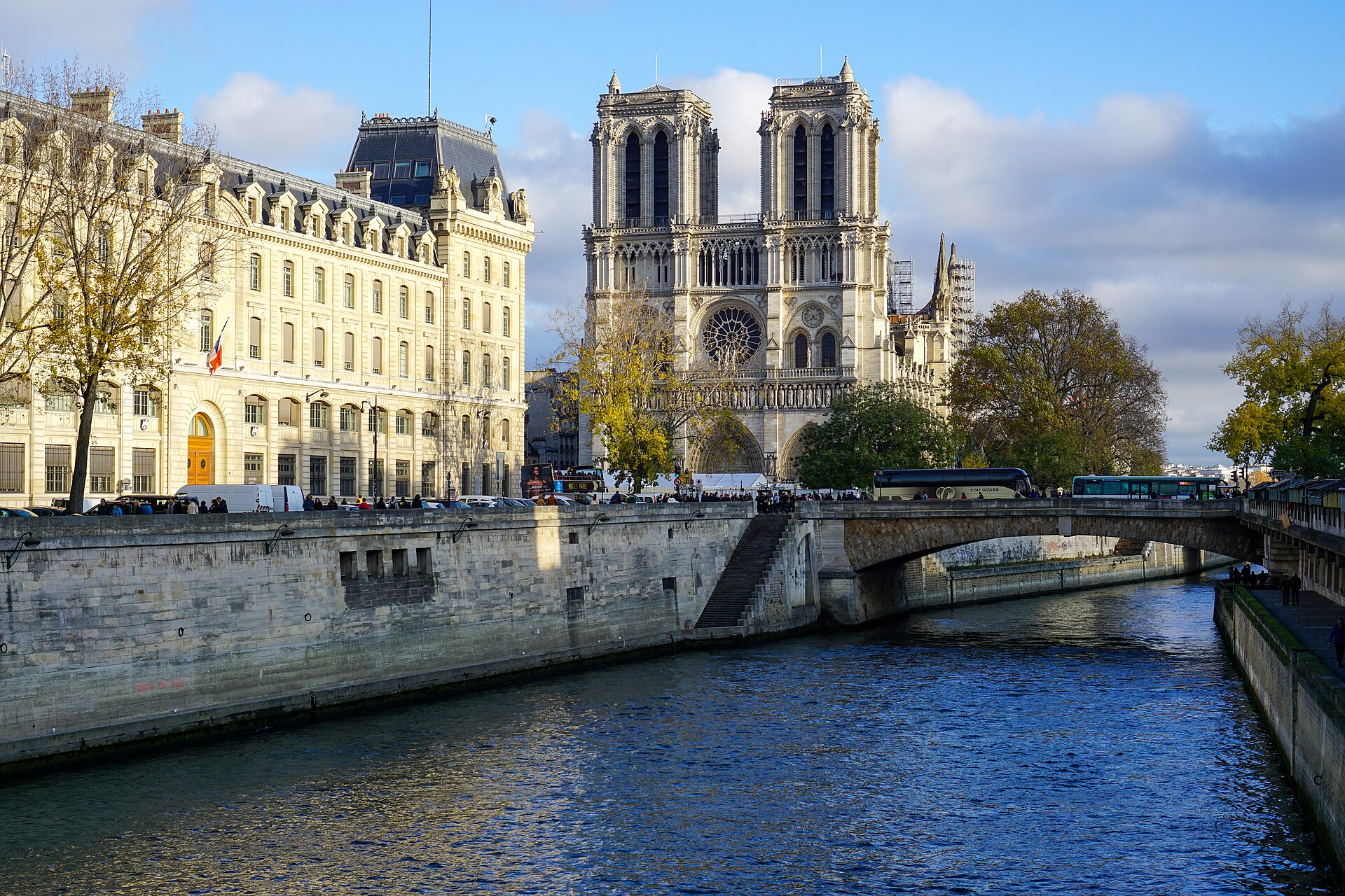 Sunlit Notre-Dame and the banks of the Seine in Paris.
